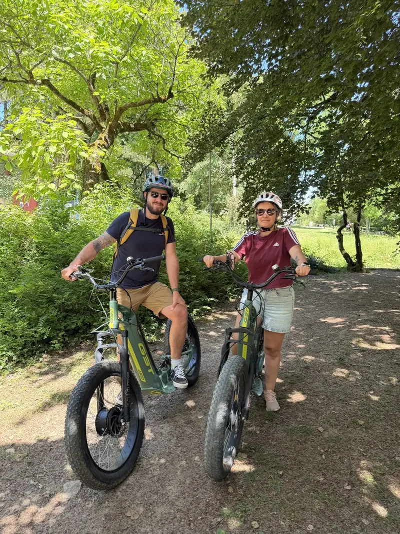 Un couple souriant sur deux trottinettes