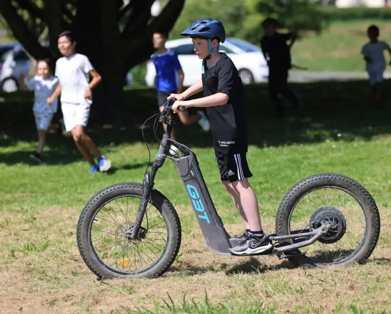 Un enfant sur sa trottinette, sortie en famille