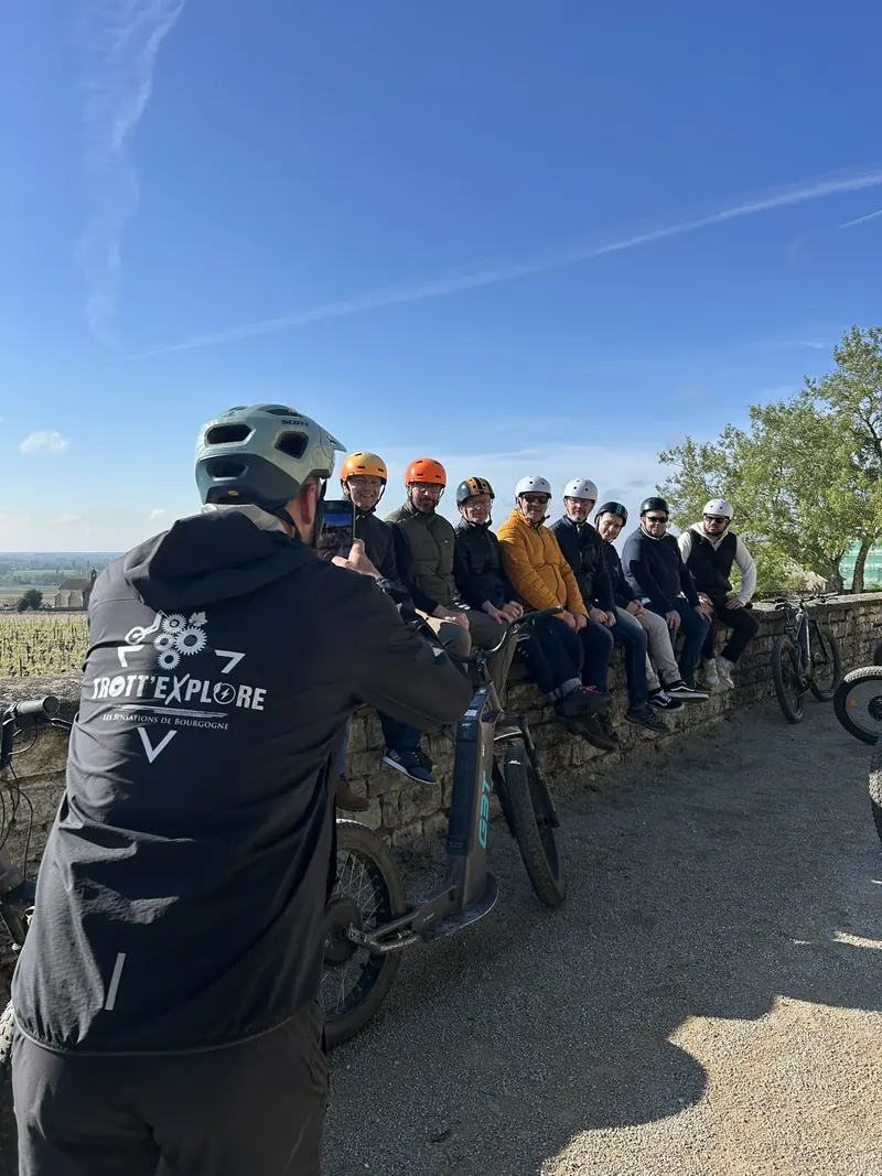 Le guide face au groupe, assis sur un muret