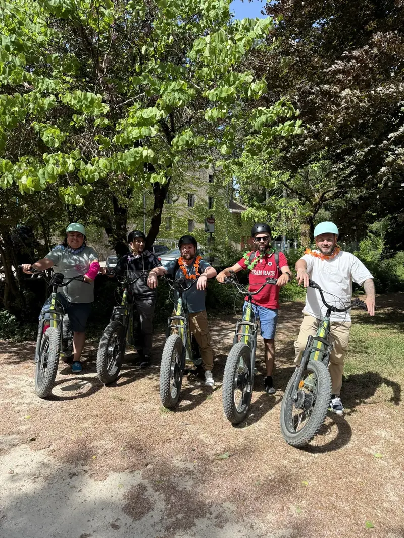 Cinq amis sur leurs trottinettes sous les arbres