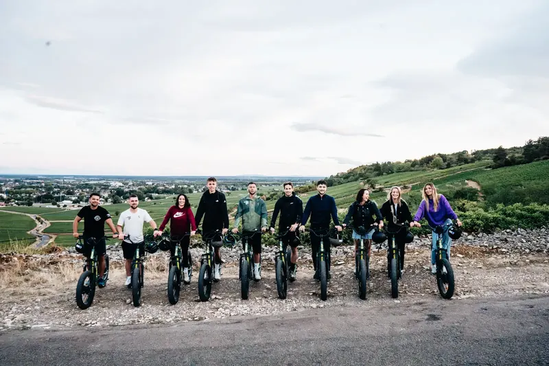 Un groupe aligné sur les trottinettes face aux vignes
